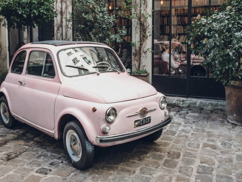pink FIAT 500 on gray concrete floor